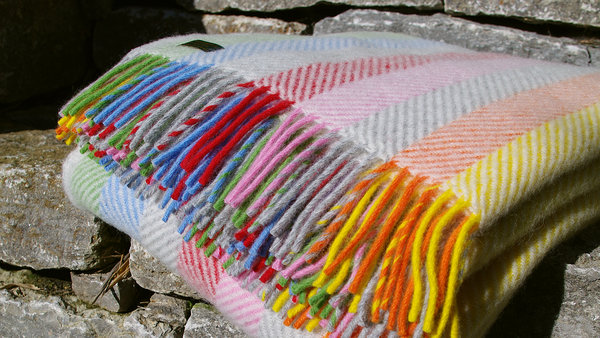 Wolldecke Rainbow Stripe von Tweedmill aus reiner Wolle. Ein Plaid in Regenbogenfarben im Herringbone Design